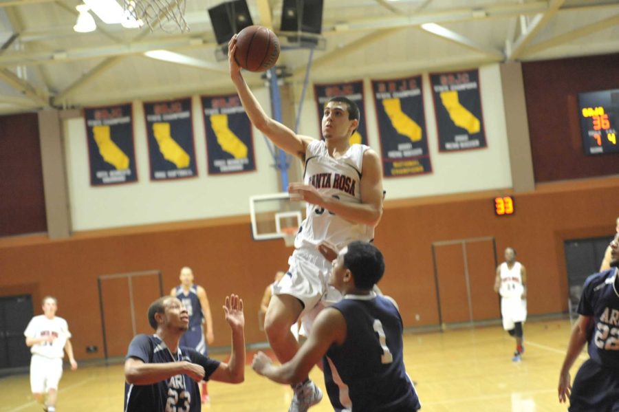 Men's basketball player Brian Johnson finishes a layup against American River College.