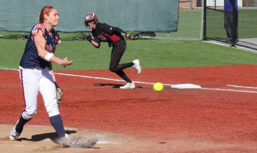 SRJC pitcher Courtney Luchessi hurls a pitch as a Sierra College base runner attempts to steal second.