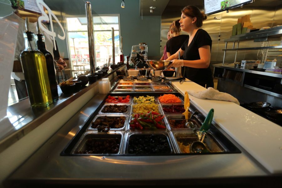 A server prepares a personalized salad for a customer at Bianchini’s, a new restaurant on Mendocino Avenue that offers a variety of sandwiches and salads.