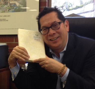 SRJC President Dr. Frank Chong gets cozy with his choice from the "Blind Date with a Book" program part of the "Love Your Library" February event at SRJC.