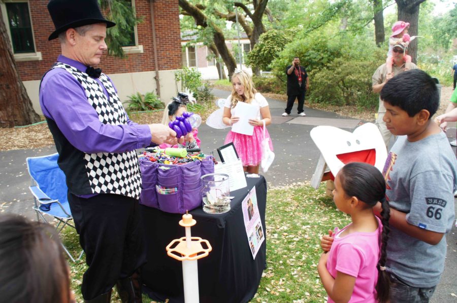 A skilled balloon artisan crafts animals for kids.