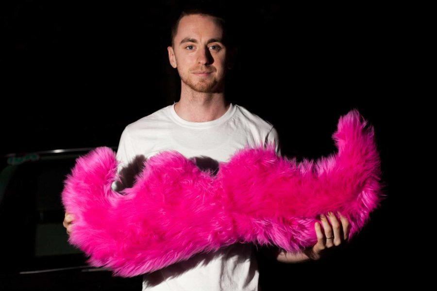 Lyft driver Maxwell Austinweil offers a “lyft” to riders who use the smartphone app to seek transportation. The pink mustache is the company’s trademark. 