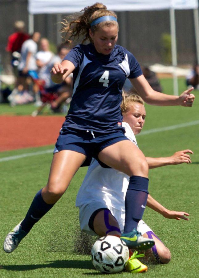 Kayleen Belda absorbs a Lassen slide tackle while maintaining possession of the ball against Lassen Community College Thursday Aug. 28 at Sypher Field.