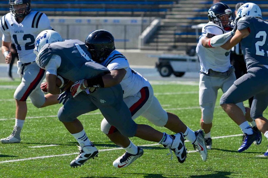 Vai Taito wraps up and stops the College of San Mateo running back Oct. 18 at CSM in San Mateo.