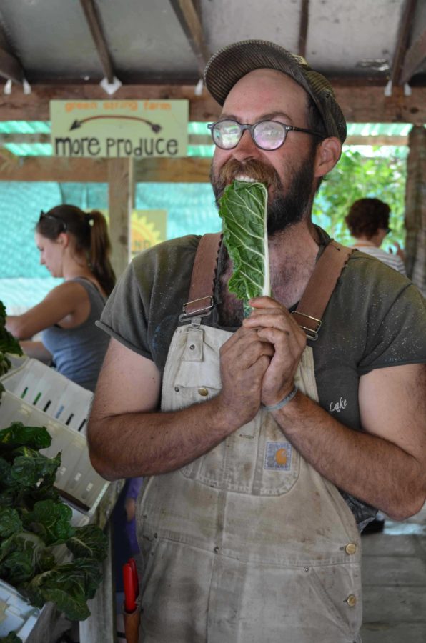 Former intern and current employee, Connor Maguire, 29 bites into a Green String Certified leaf of chard at the Green String Store in Petaluma, where the public are welcome to purchase the product of the interns’ hard work.