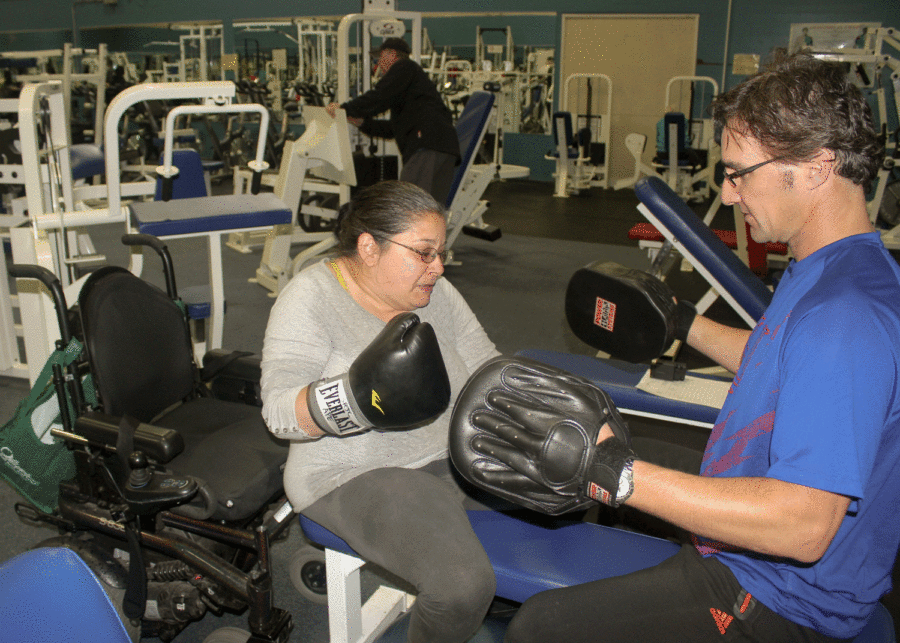 Adapted Physical Education student Jessie Morgan practices boxing with instructional assistant John Adams.