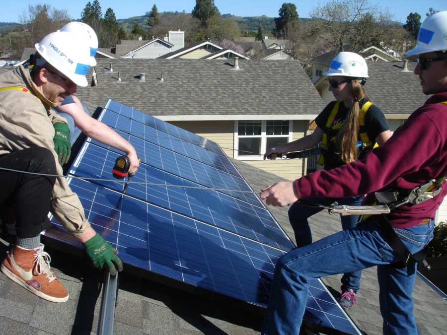 Students checking one of the solar panels on the roof of an SRJC building.