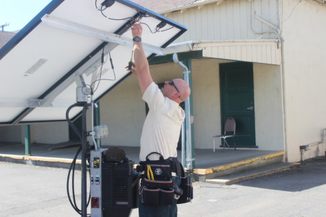 Professor Kevin Byrne prepares a solar panel for installation.