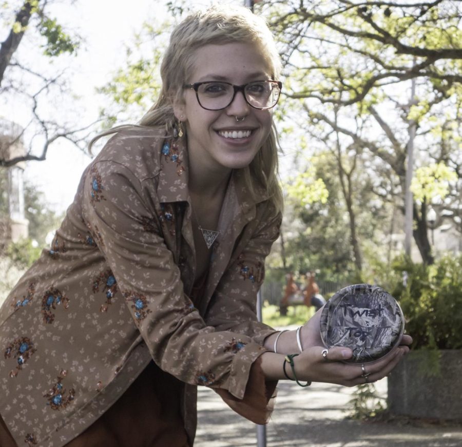 An SRJC student picks up a letterbox outside Emeritus while on her way to class.