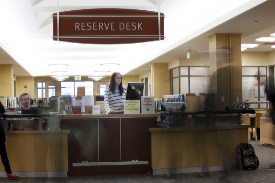 Student employees Hannah Sansom and Tyler Blatt assist check outs for short-term loans of textbooks at the reserve desk at the Doyle Library on the Santa Rosa Junior College campus Aug. 20.