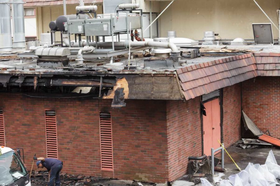 A worker cleans up after a fire damaged Tauzer Gym on the Santa Rosa Junior College campus in Santa Rosa, Calif. on the morning of Sept. 14 2015