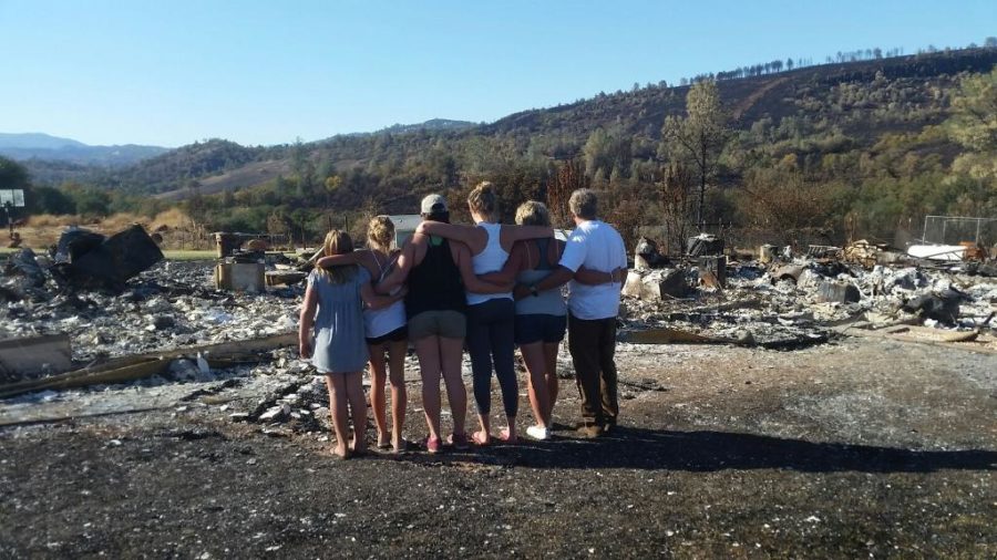 SRJC student and basketball player Ashley Hart and her family stand in front of the remains of their burned house.