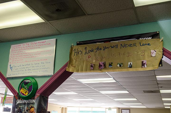 Friends and family put up signs in memory of Nick Owen at Outer Planes Comics and Games.