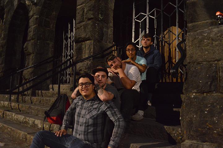 The five members of the Acrylics sit outside of an old church in downtown Santa Rosa.