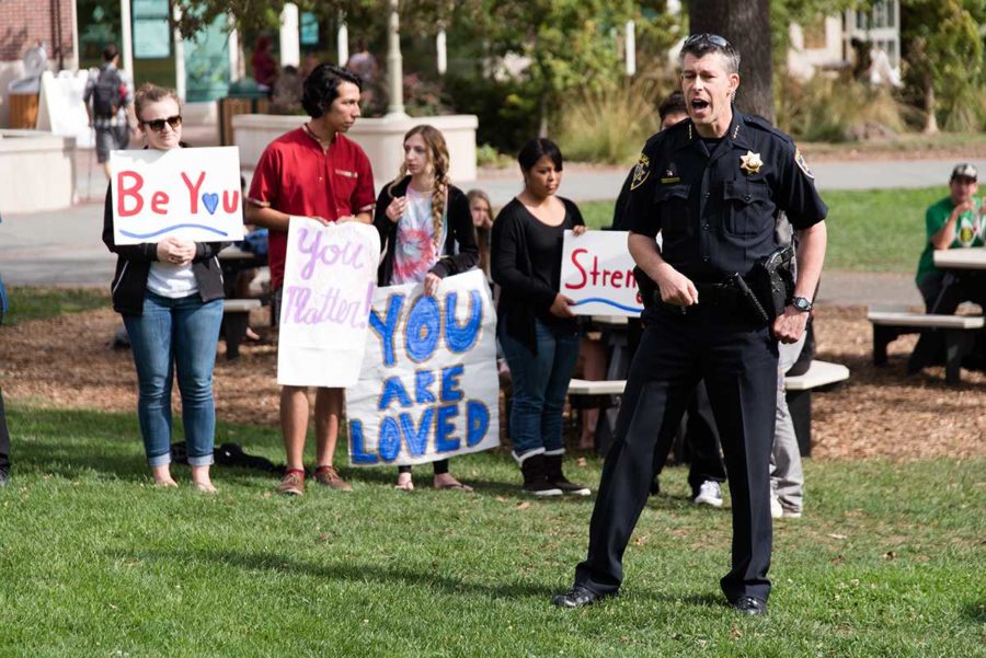 SRJC District Interim Police Chief Robert Brownlee addresses students on police’s role in mass shootings with the SGA behind him with signs. 