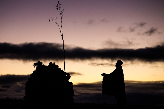 Joshua Lanakila Mangauil performs a Hawaiian chant at a shrine near Mauna Kea. (Photo originally on Nature Publishing Group.)