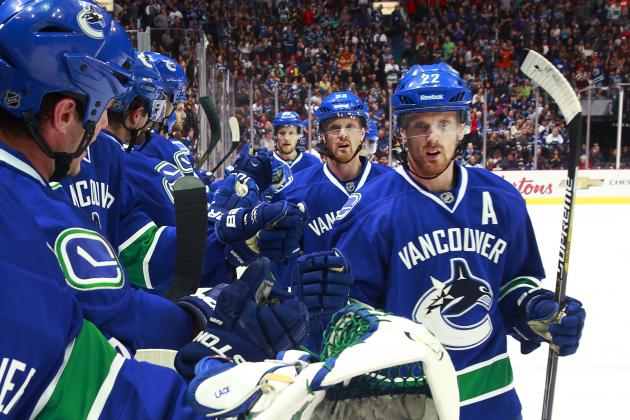 The Sedin twins, Henrik and Daniel, are congratulated by teammates after scoring a goal.