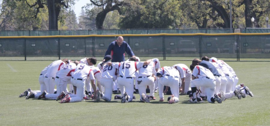 Assistant coach Tom Francois gathers the Bear Cubs together for a team prayer before the beginning of their game. 