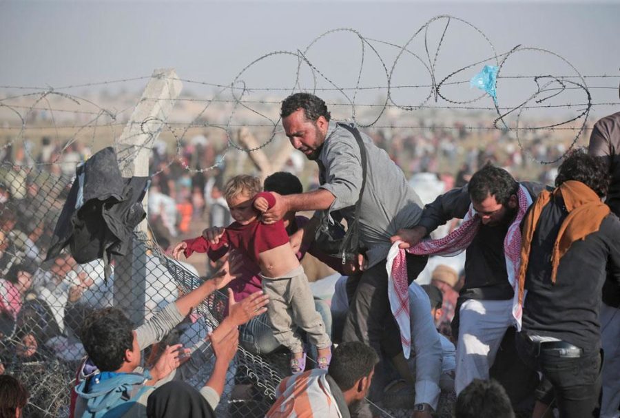 Refugees struggle to cross the border into Turkey.