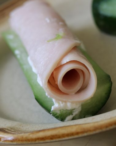 Turkey rolls on a cream cheese spread over a cucumber is the perfect snack for a hot summer day.
