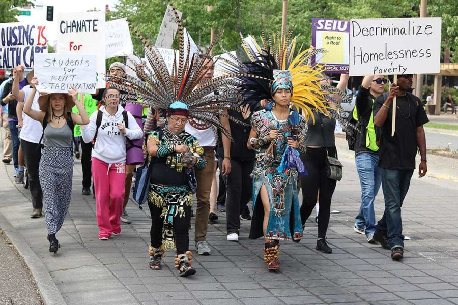 Aztec dancers lead the procession of passionate protesters on the way to City Hall. 