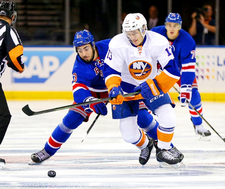 Sep 27, 2016; New York, NY, USA; New York Rangers center Mika Zibanejad (93) and New York Islanders center Mathew Barzal (13) battle for a loose puck during the first period during a preseason hockey game at Madison Square Garden. Mandatory Credit: Andy Marlin-USA TODAY Sports