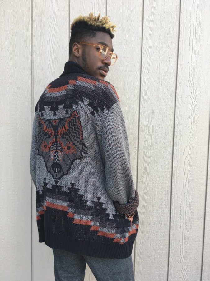 Diomande looking back at his fox-tribal knit sweater from Urban Outfitters.