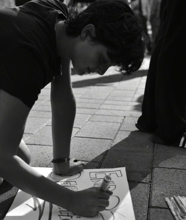 A protestor draws on poster board for a Sep. 2017 protest