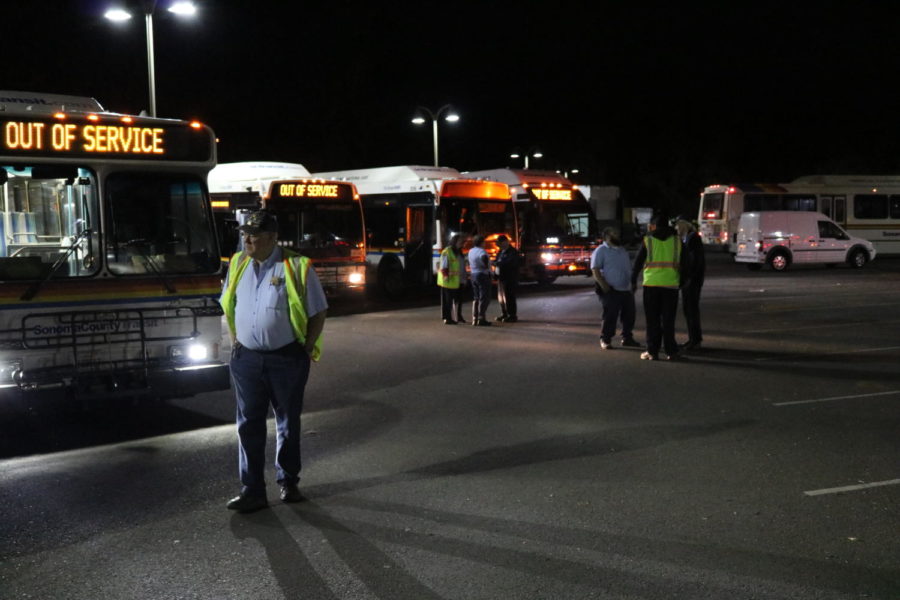 Evacuation buses roll into Sonoma State University as precautionary measures for students.