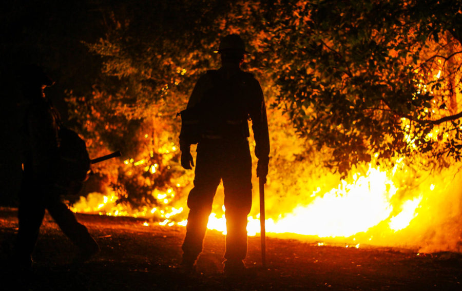 A firefighter watches a controlled burn outside the juvenile correctional facility near Kenwood.