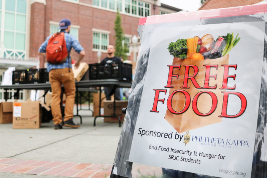  Vice President of Student Health Services Ryan Sansome helps a student at the Student Government Assembly and Phi Theta Kappa’s Wednesday food bank outside Bertolini Hall. The student organizations are working to institutionalize a food pantry to combat food insecurity on campus. Photo by Charlotte Maxwell.