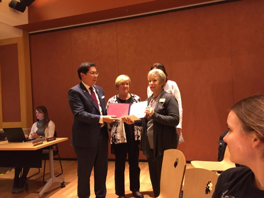 President Frank Chong presents an Honorary Associates Degree for Christina Hansen to her stepmother, Jennifer Watson.