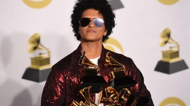 Bruno Mars is the big winner as he holds his six Grammy awards with a smile.