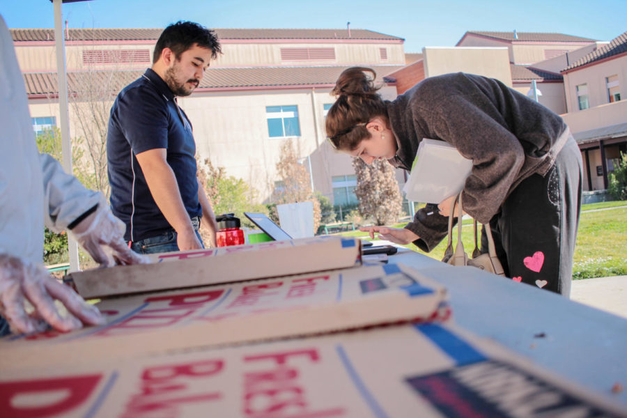 Student Ambassador Steven Blacencia hands out pizza to students in Rotary Plaza for Pizza Party day on Tuesday. Blacencia is a member of Anime club and helped coordinate events throughout the Petaluma campus’ Welcome Week.
