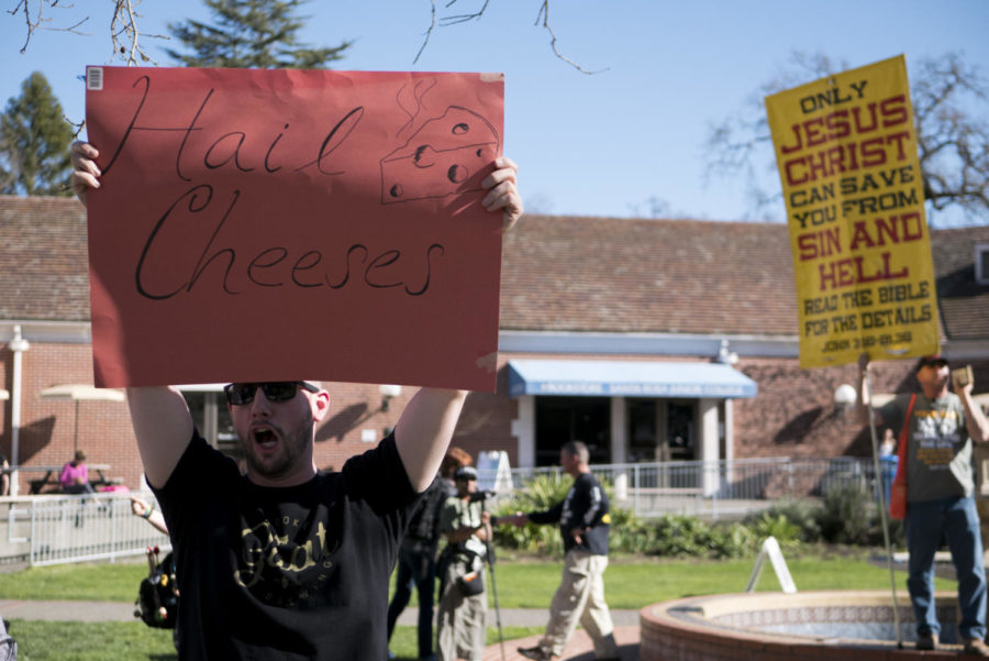 One student's sign stands out. "Hail Cheeses" drew smiles and laughter in front of the religious group.