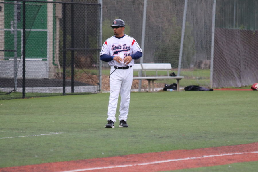 Assistant coach Ben Buechner giving the signs to first base.