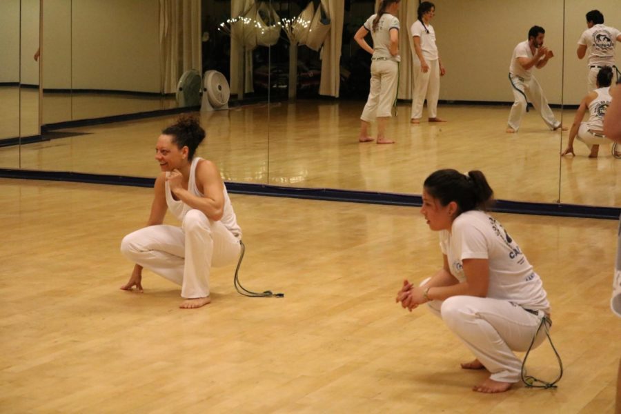 Professora Sarará, Capoeira mestre (left), and club leader Curumin Winter-Hare observe students as they practice Capoeira, a Brazilian style.  