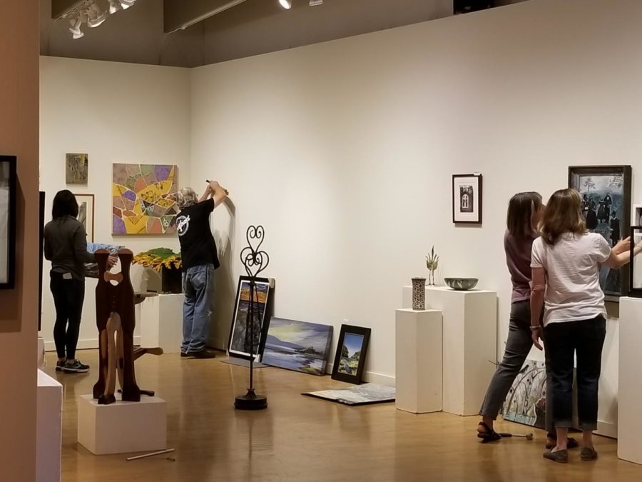 Artists install the Main Preview Exhibit for Art Trails Open Studios at Sebastopol Center for the Arts.