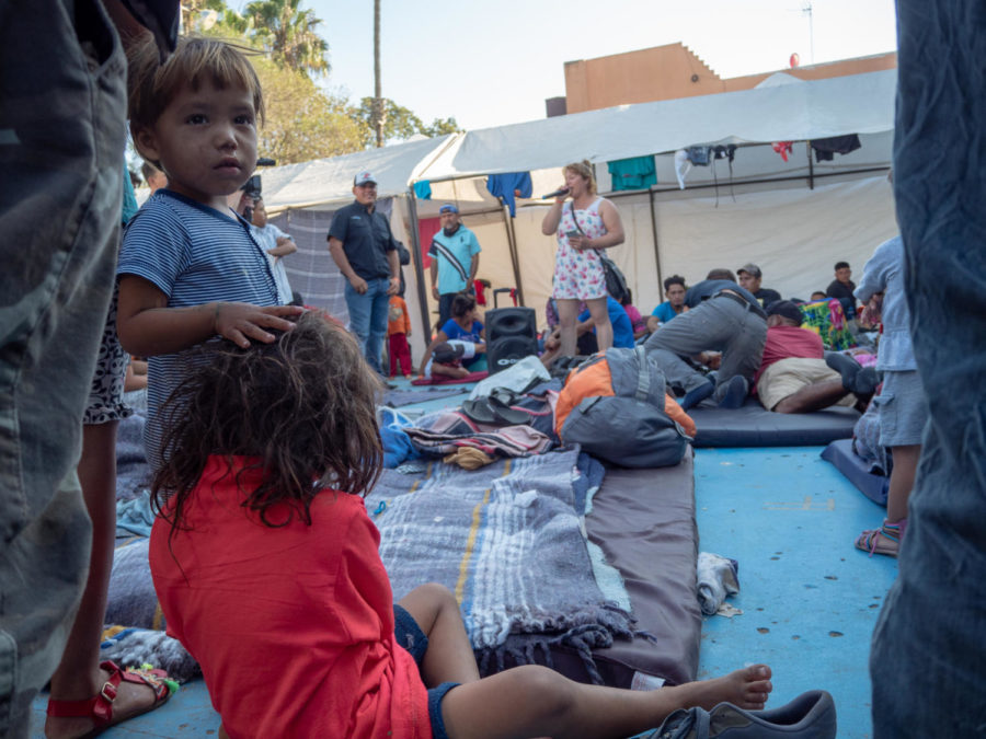 Two children among others in the caravan listen to a female entertainer. 