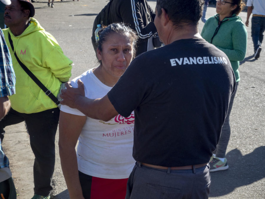 A pastor comforts an emotional woman by telling her "God is with you". 