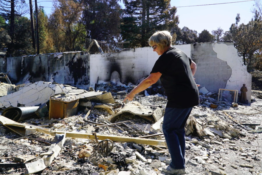 Tyra Benoit identifies bits of her belongings in the ash heap that was her home. 