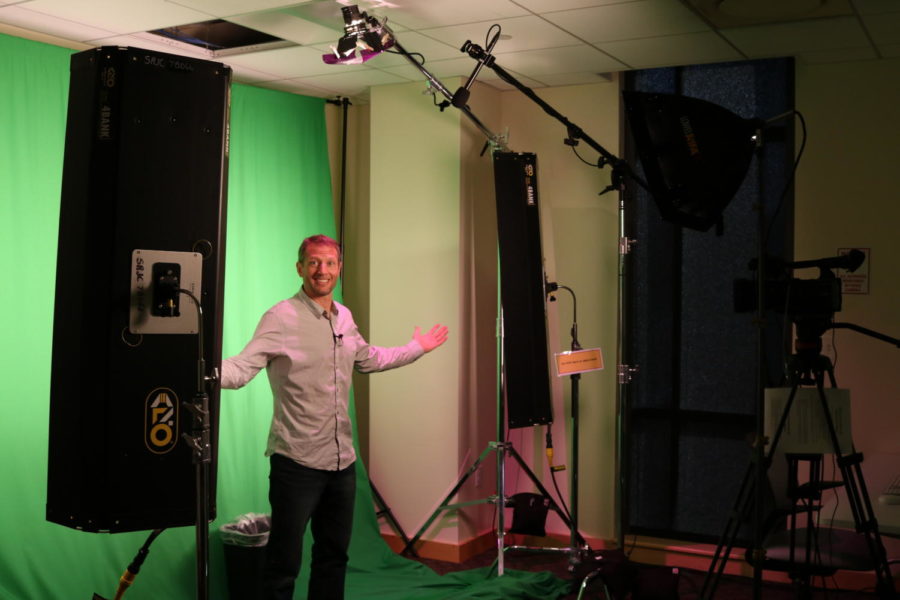 Digital filmmaking instructor Brian Antonsen shows off the one switch  lighting in the green screen room.