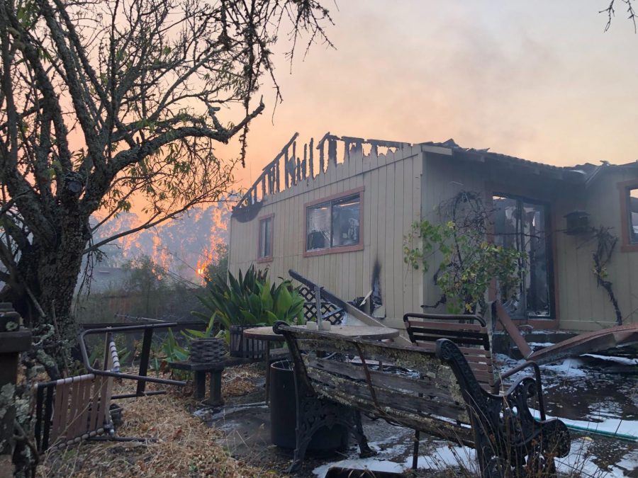 The exterior of a Windsor tract home remains surrounded by the ashes of personal belongings and outside furniture on Brooks Road. 