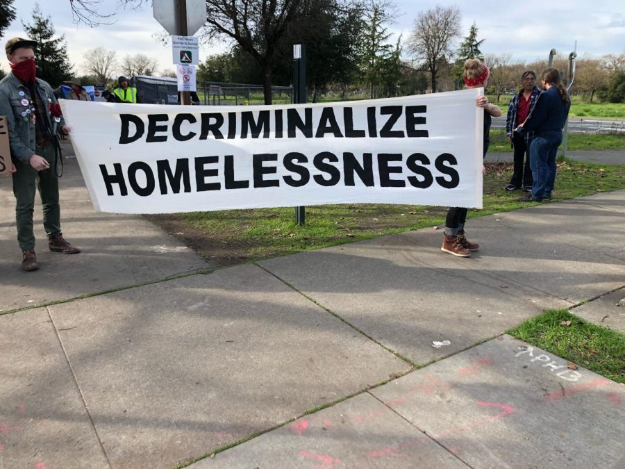 Protesters hold a sign toward police on the other side of Stony Point Road. No one is sure what the future holds for the residents of the Joe Rodota Trail, but the county is certain they will be gone from that specific location by Jan. 31.