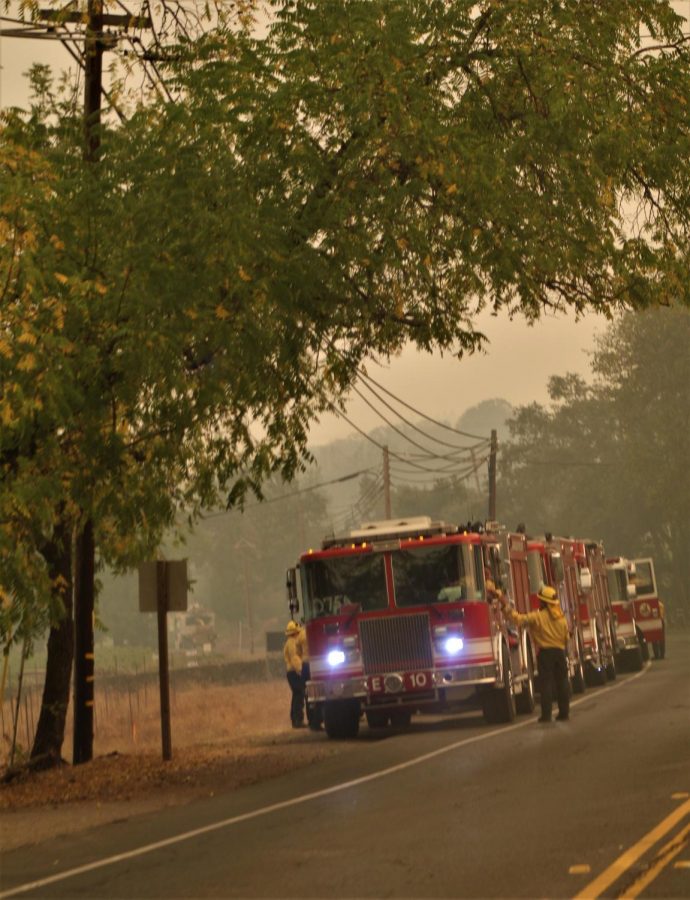 Firefighters shake hands in front of an engine parked on Highway 29.