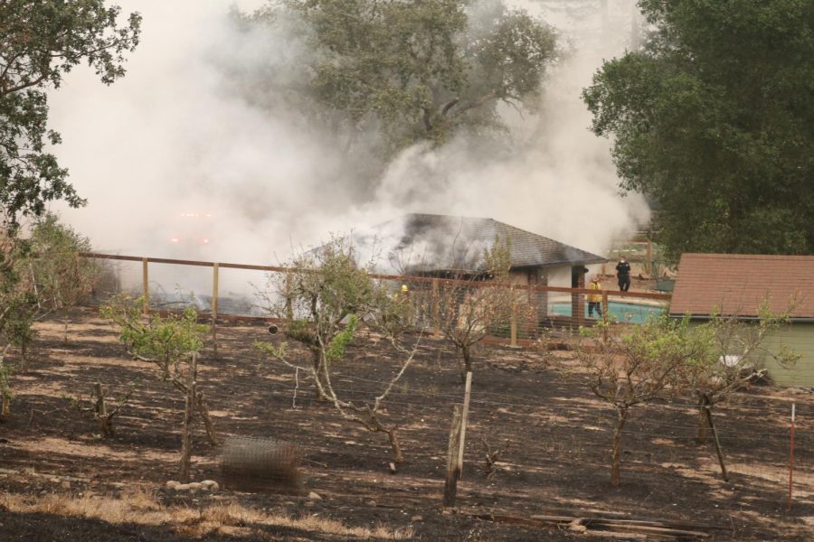 Firefighters extinguish flames on a pool house on Los Alamos Road.