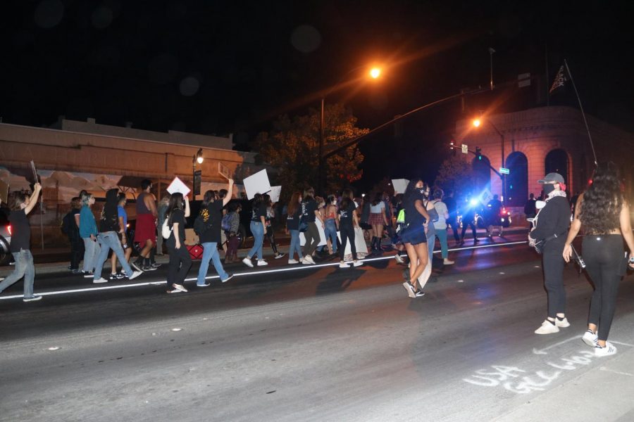 Protestors march on Washington Street carrying signs for the BLM movement.