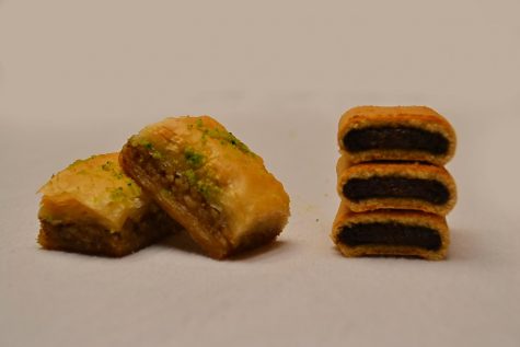 Two pieces of baklava on the left and three stacked pieces of fig newton on the right.