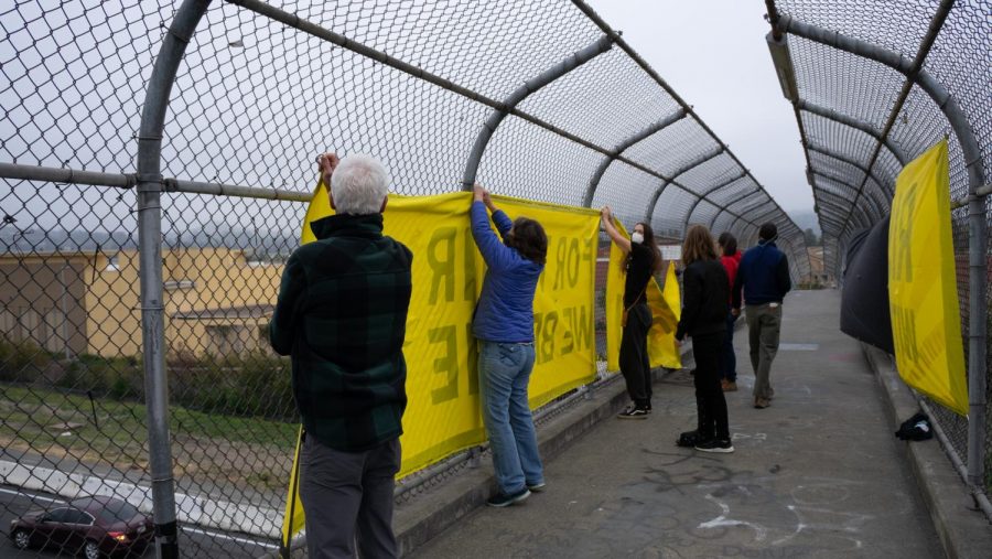 Climate activists hang banners on Highway 101 overpasses to call attention to the climate crisis.