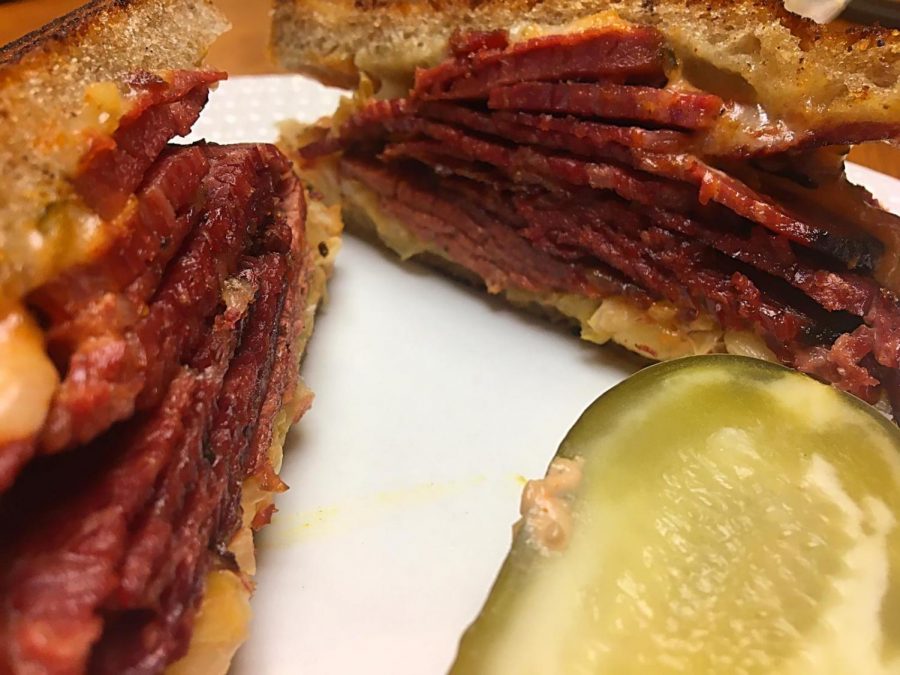 A reuben sandwich and pickle from Grossmans Noshery & Bar